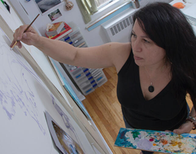 Detail photograph of artist Josie Gonzalez holding paint palette in her studio